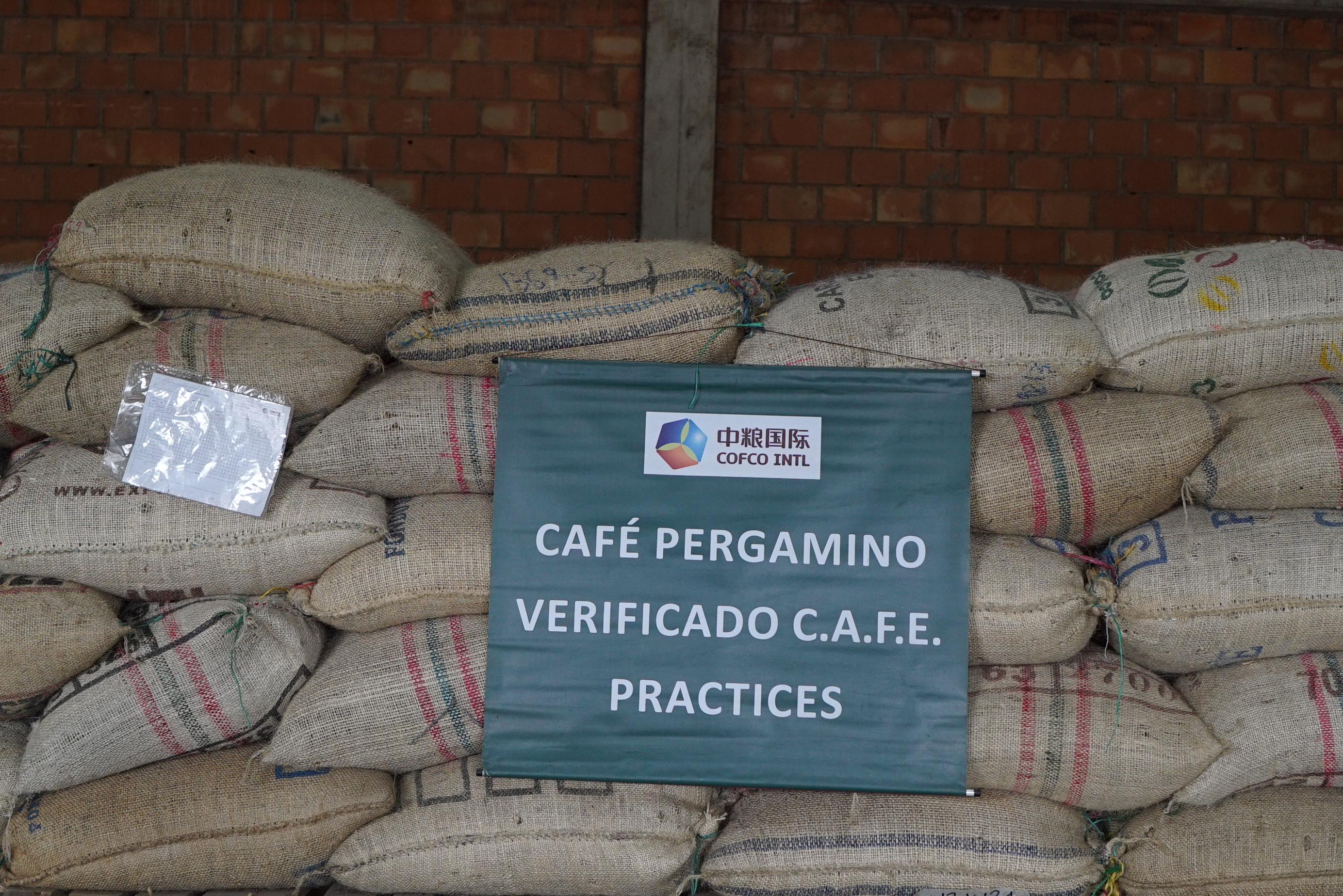 Café certificado pela C.A.F.E. esperando para ser enviado à Starbucks no armazém da COFCO em Huila. Na Colômbia, a COFCO trabalha com os programas de verificação e certificação da UTZ, Rainforest Alliance, C.A.F.E. Practices, Organic and Fair Trade.